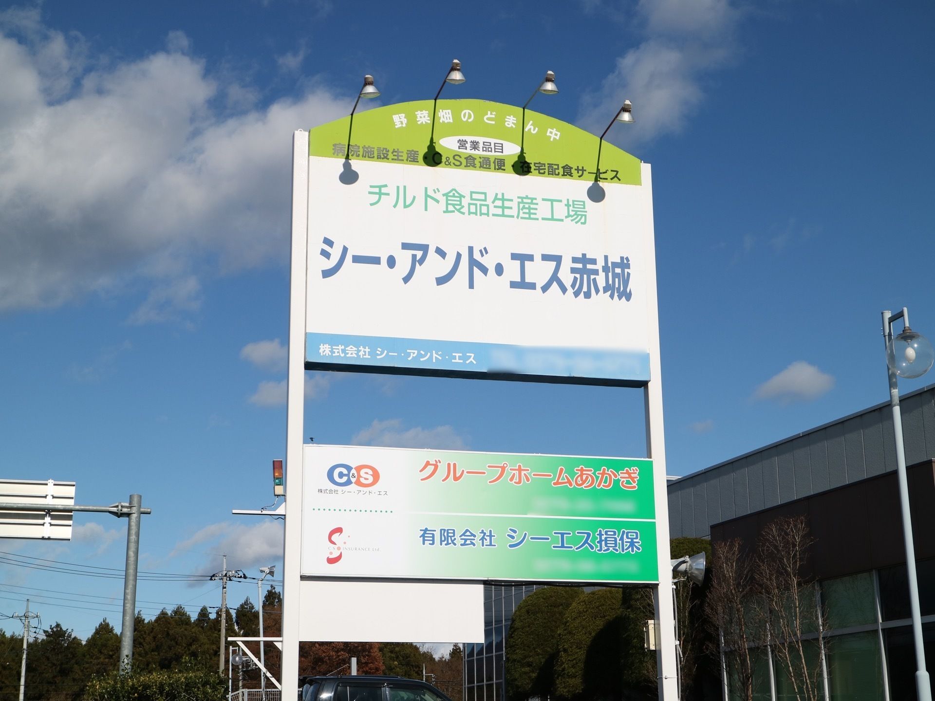 街灯よりも高さのある大きな施設看板が建てられている。立看板の上部には4つのライトが取り付けられている。