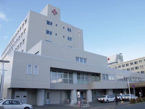 当施設の近くにある総合病院。広い敷地に白い大きな病院の建物がある。病院の前にはタクシー乗り場がある。