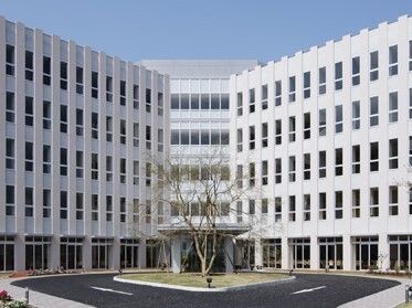 玄関前に車寄せがある、大きな白い5階建ての施設建物