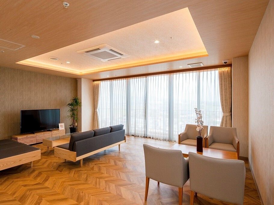 ゆったりとしたソファーが置かれたラウンジ。大型のテレビも設置されている。壁には絵画がかけられている。
