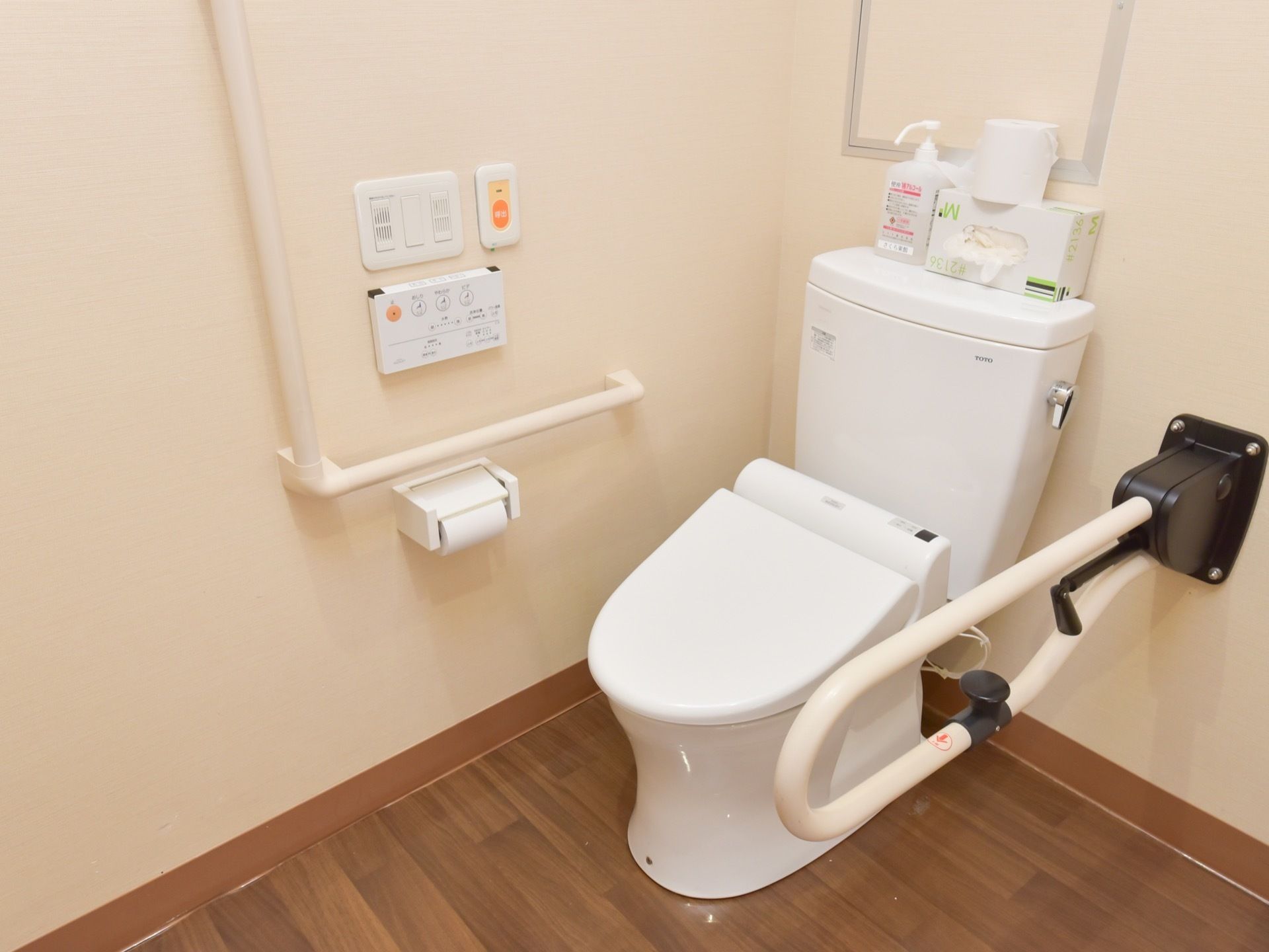 トイレには温水洗浄便座を設置している。壁には手すりと、温水洗浄便座のスイッチパネル類、緊急ブザーが備え付けられている。