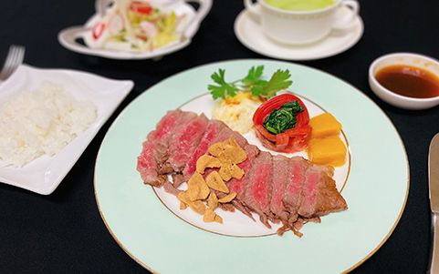 にんにくチップをのせた肉料理とライスとスープのセット