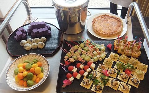トマトやチーズの串、カナッペ、パイやチョコレートのお菓子が並んだテーブル