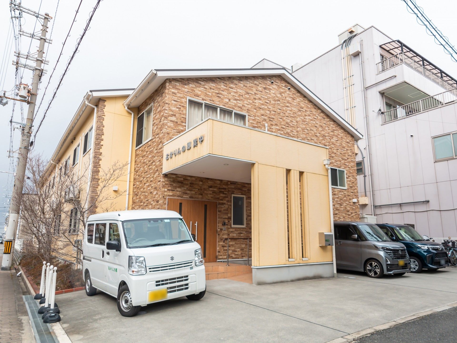 車椅子に座っている高齢女性と隣りに寄り添う男性ヘルパー