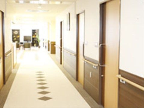 壁に手すりが付いており、引き戸タイプのドアが並ぶ廊下