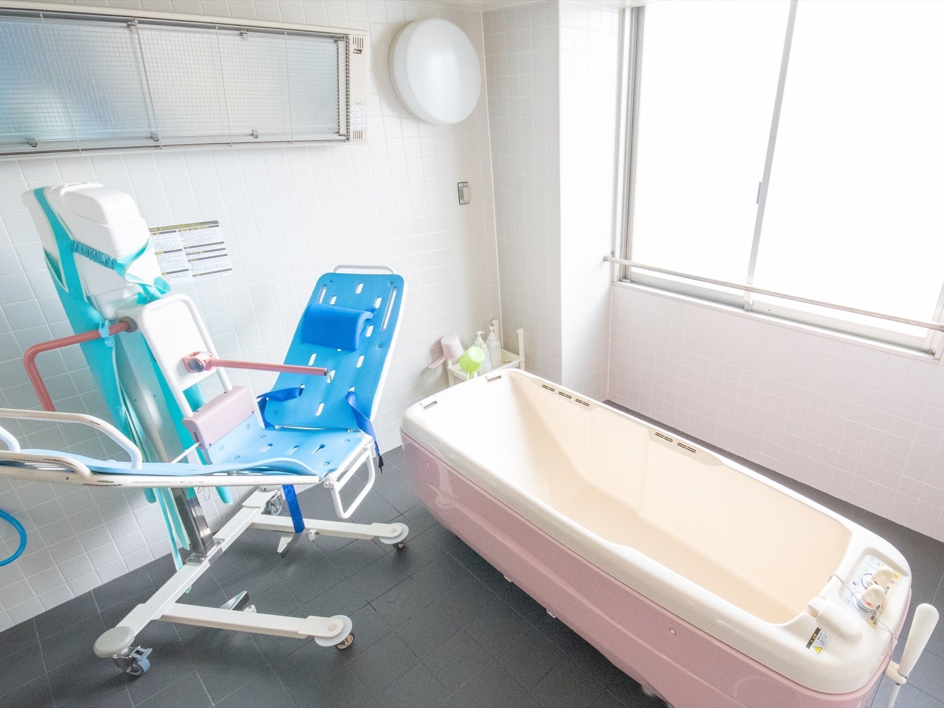浴室には特殊浴槽やストレッチャーが用意されている。手桶のほかにシャンプーとリンスが置かれたかごが用意されている。
