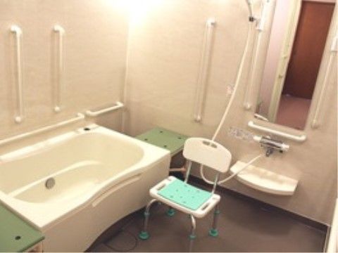 白で統一された壁面と浴槽はきれいに磨かれており、照明の光を明るく反射している。洗面用の台は低めの位置に設計されており、前方に大きな鏡がある。
