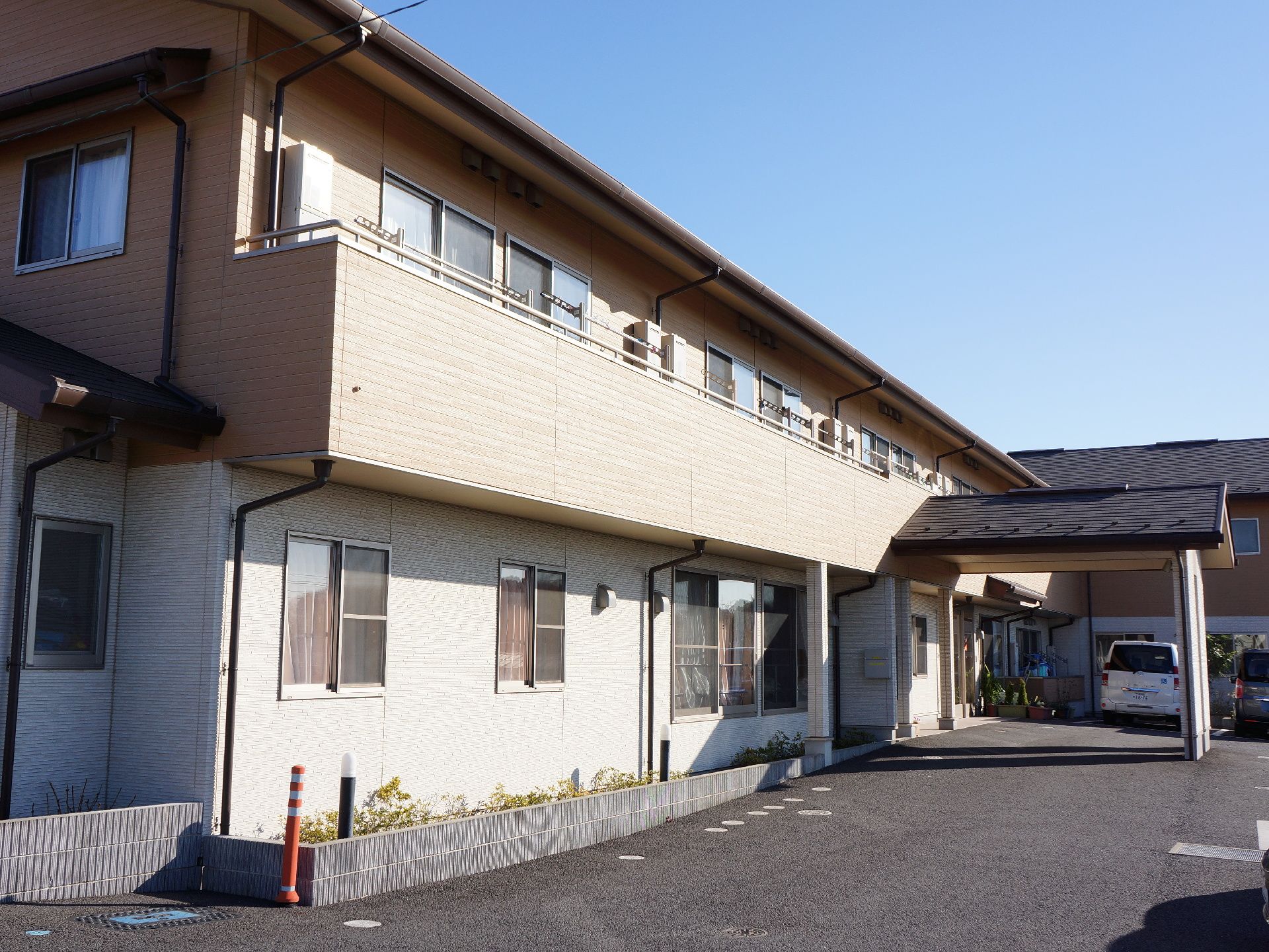 建物周辺に植え込みがあり、少しスペースを置いた位置に駐車場がある。スペースがあることにより車が誤って建物に衝突することを防ぐ。