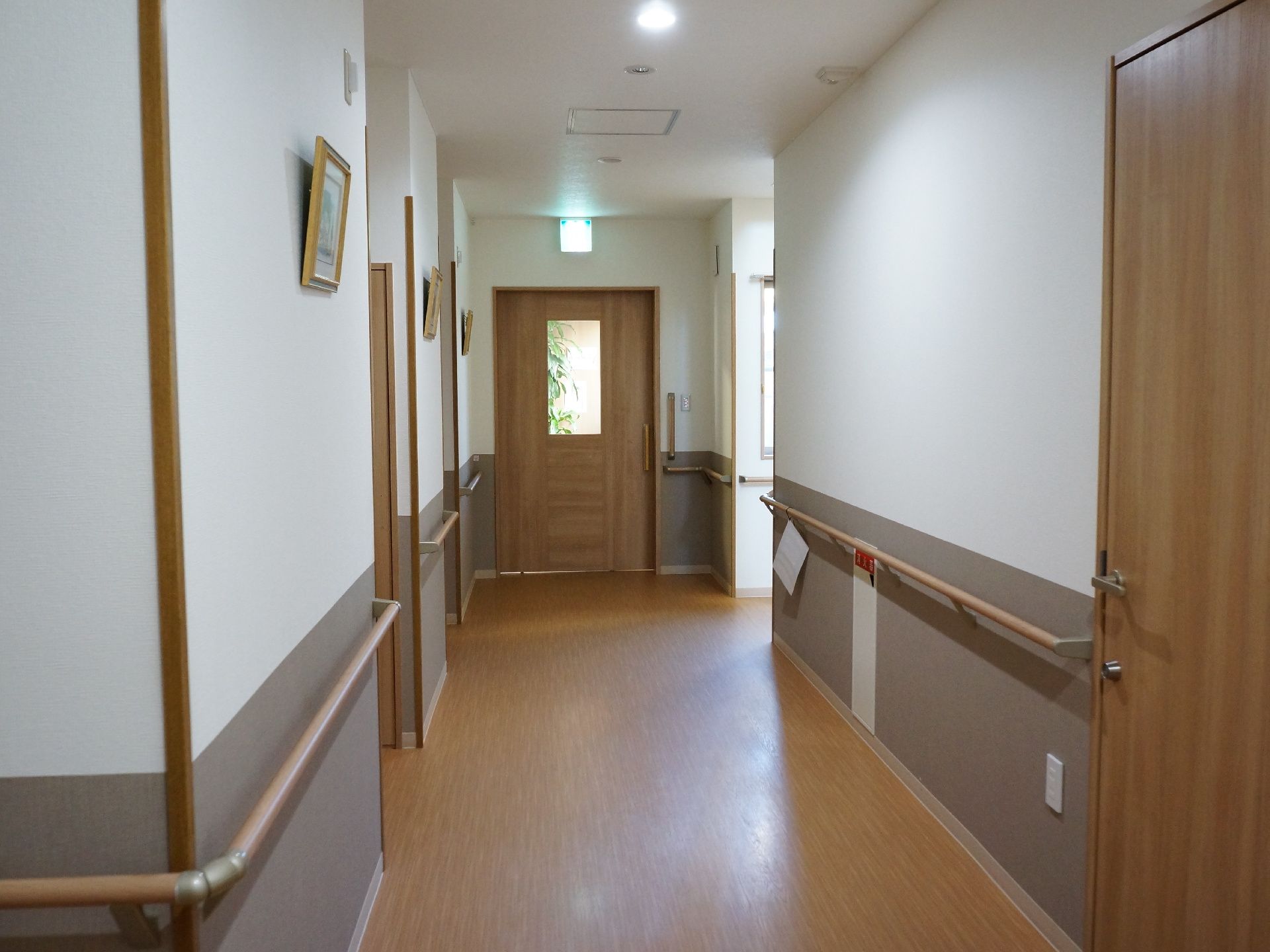 広々と清潔感のある空間で、突当りが出入り口になっている。両側には手すりが完備されているので移動が安全。消火器も完備。