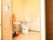 広々としたトイレ空間に、洋式便器と手洗器が設置されている。出入り口にトイレと車椅子のマークが貼ってある。