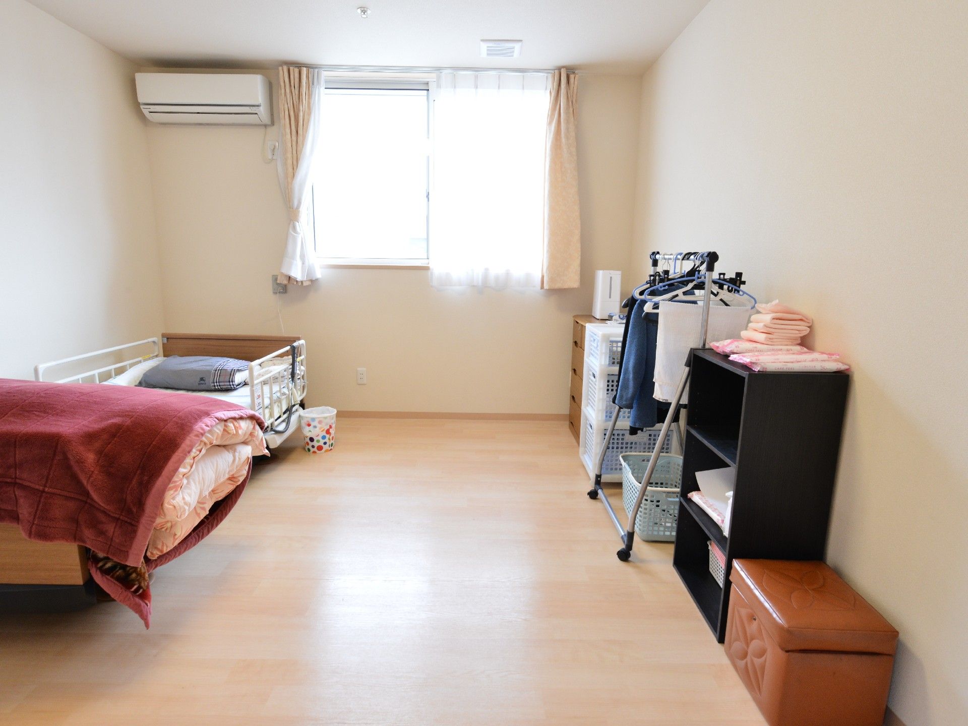 窓とエアコンの付いた居室。本棚などの家具も自宅より持ち込んでいる。