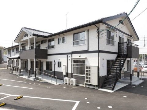 前面に駐車スペースを設け、非常階段を設置した2階建ての施設外観
