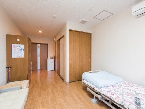木目調のスライド式扉の収納クローゼットが造り付けられた居室