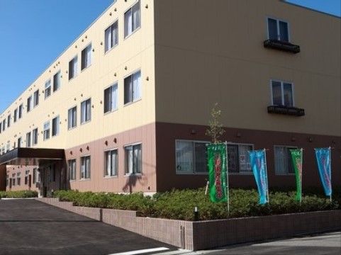 「サービス付き高齢者向け住宅 そよ風」の外観。クリーム色と赤茶色のタイル柄を施され分かりやすい目印になっている。
