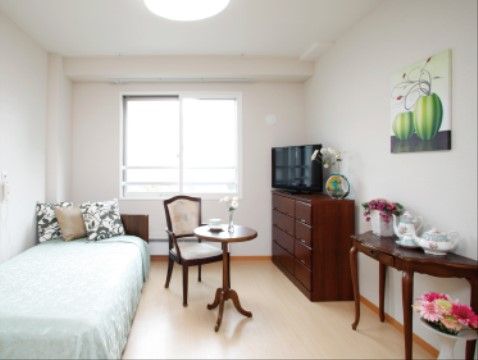 「サービス付き高齢者向け住宅 そよ風」の居室。ベッド横の壁には、緊急コールを設置されているので、横になったままでも手の届く距離である。