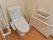 トイレには洋式便器が設置されている。便器の両側の壁には横長の手すりが取り付けられている。呼び出しボタンもある。