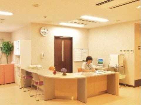 コーナーに設けられた受付スペースで座って作業する女性スタッフ