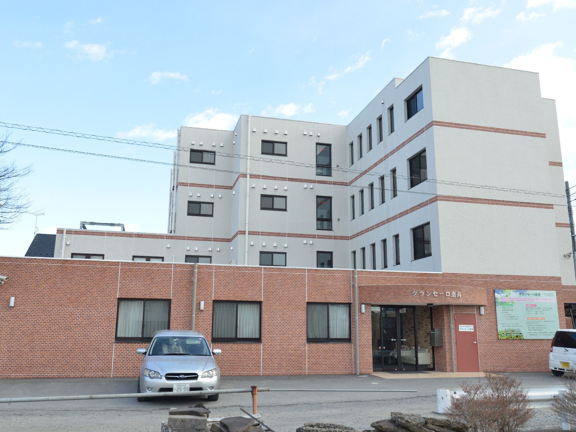 「グランセーロ恵喜」の外観。施設は4階建ての灰色と褐色の落ち着いた外観。