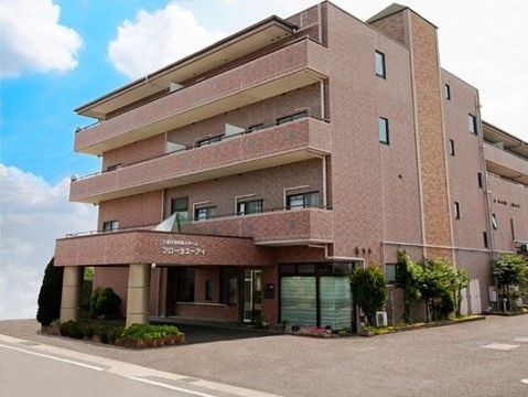 フローラユーアイの外観。大きなマンションのような施設外観です。暖色の外壁が落ち着いた印象を与えています。
