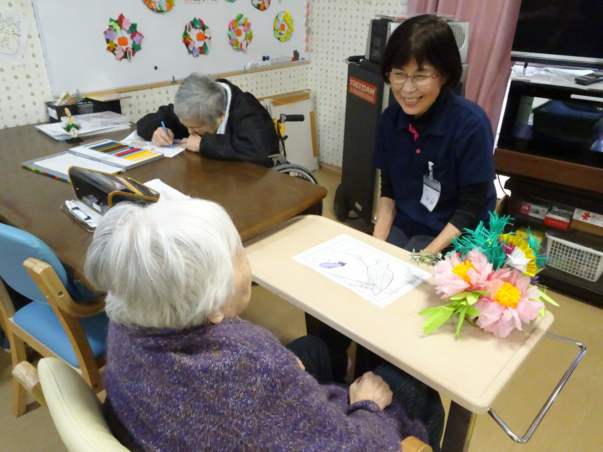 拳を突き出しリハビリをする高齢女性と指導をする理学療法士の男性