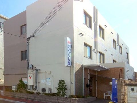 外壁に施設看板が設置され、屋根付きポーチを完備した３階建て施設の外観
