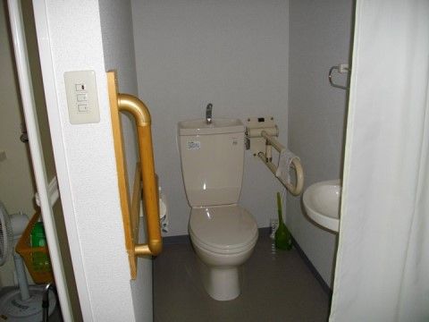 便座の横にレバー式手すりを壁に設置し、手洗い場を設けたトイレ空間