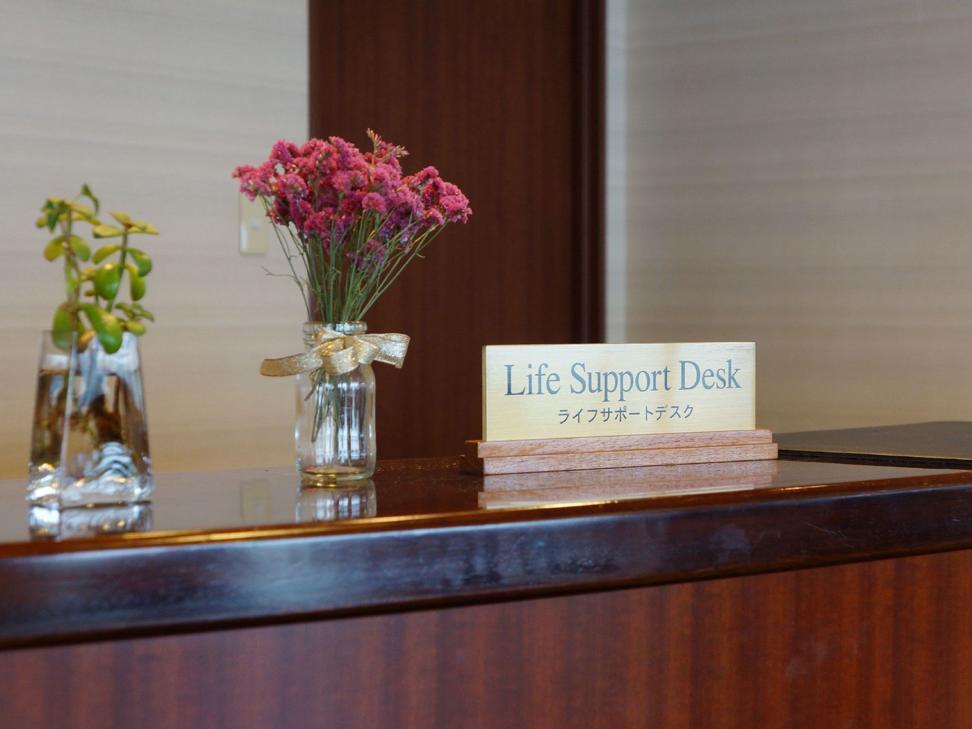 【Life Support Desk（ライフサポートデスク）】と書かれた受付である。花が花瓶にいけられていて、きれいな印象。