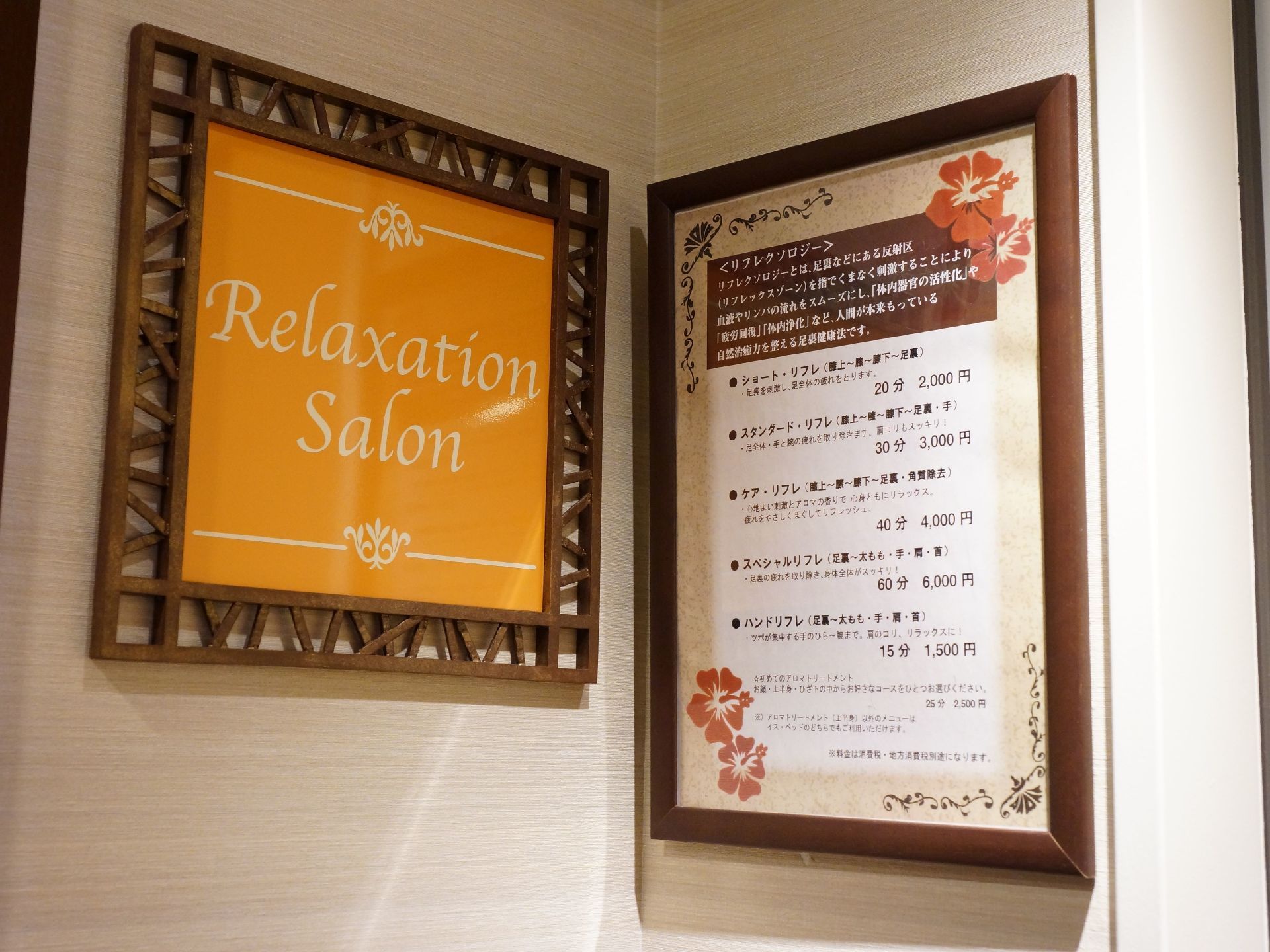 リラクゼーションサロンの看板とメニューが壁に取り付けている。また、これらはとても見やすくなっている。