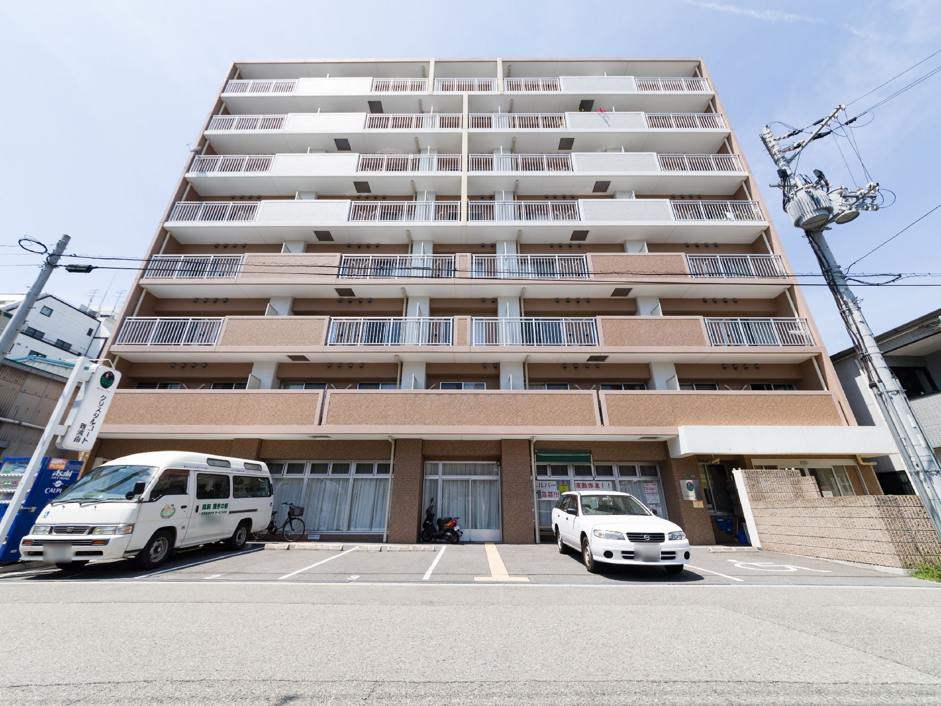 施設は、8階建てのコンクリート造り。ベランダの壁は、1~4階部分がベージュ色で、5~8階部分が白い。