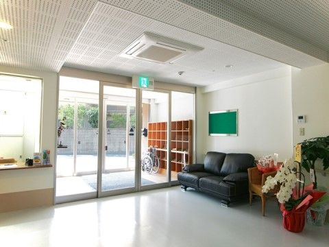 「クリスタルコート四條畷」のエントランス。待合所として3つのソファーを設置し、ゆったりと腰掛けができる。