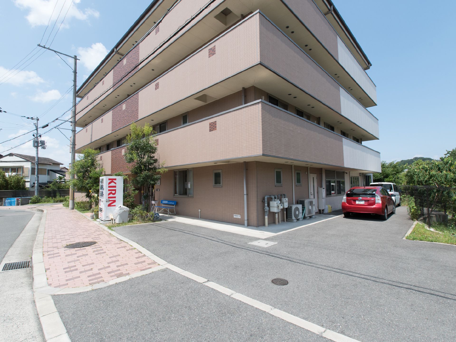 駐車場が設置されている。ベランダのある建物となっている。緑がたくさんあり、とても落ち着いた雰囲気である。