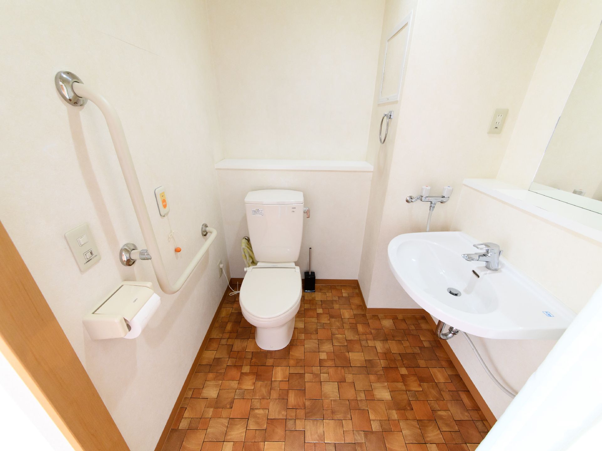 居室内にあるトイレは洋式で、個室内に鏡付きの洗面台も設置されている。便器の右壁にL字の手すりがついている。