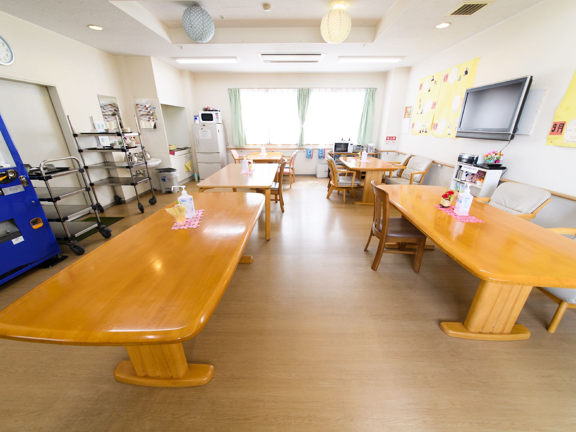 食堂は窓が大きく、太陽の光がはいるので、日中は明るい場所となっている。角が丸まったテーブルと椅子が置いてある。