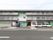 施設は3階建てになっていて、全体は薄い緑色の外観になっている。敷地内には白い車が2台停められている。