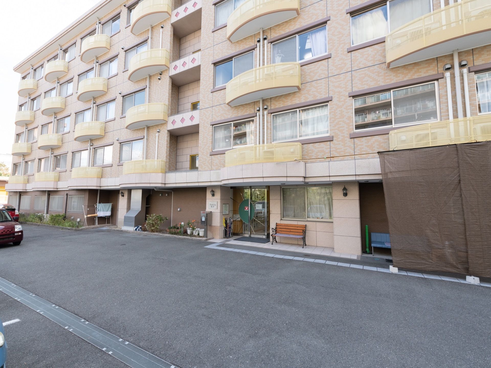 ５階建ての建物で、各居室の間にはエアコンの室外機専用のベランダが設置されている。玄関には、ベンチが用意されている。