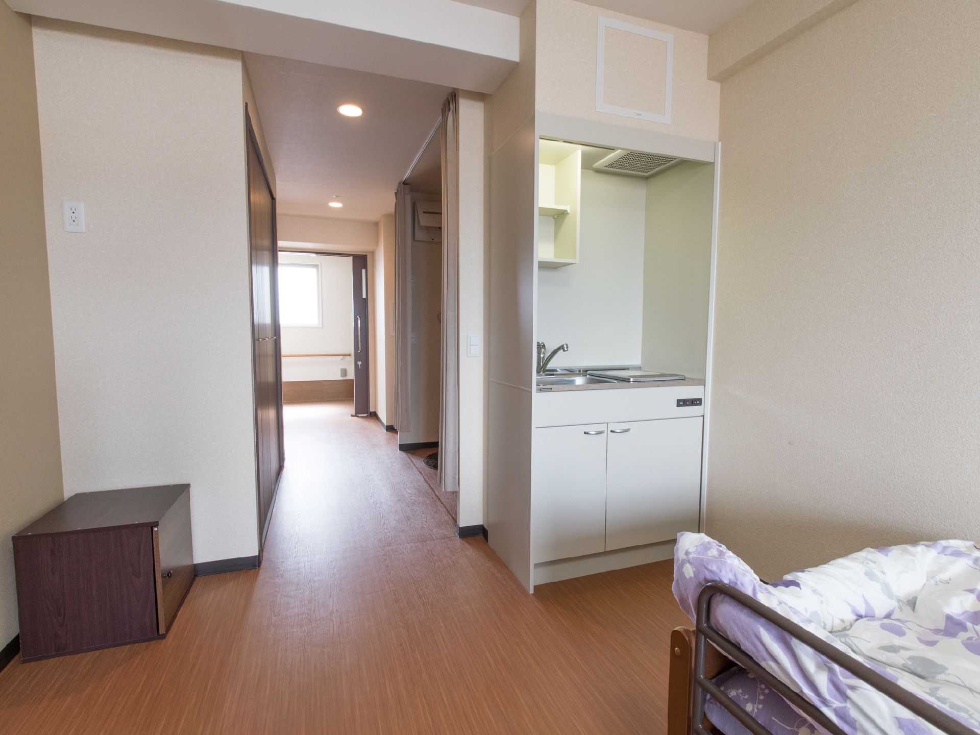 ウッドフロアの部屋で、スライド式のドアを開けると廊下があり、すぐ手すりがついているので歩きやすくなっている。