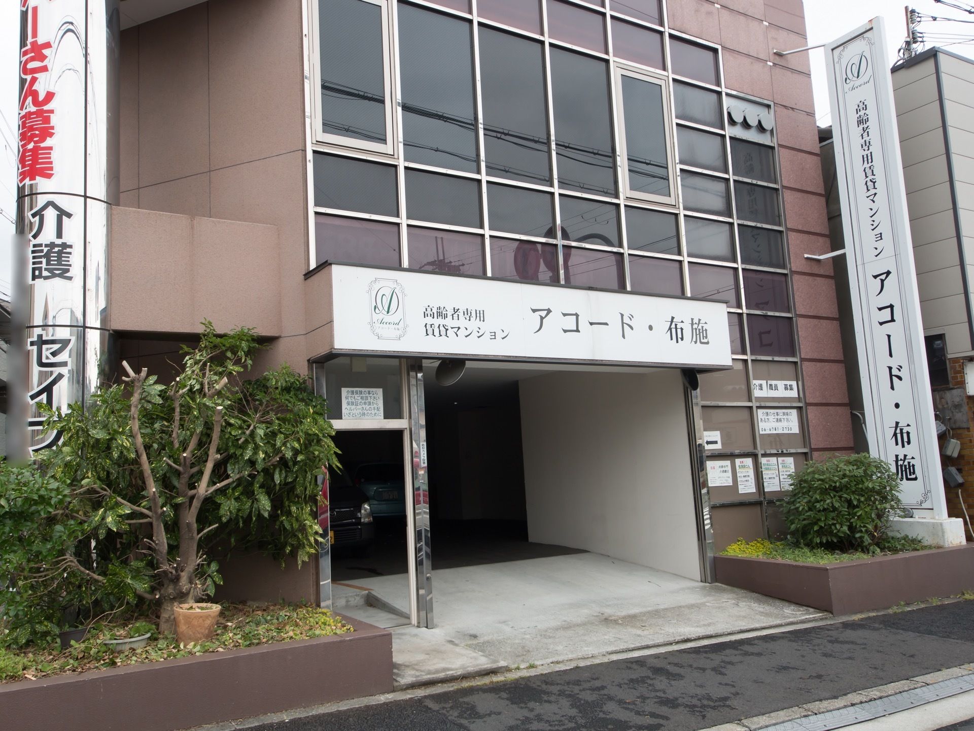 オフィスビル風の建物である。外壁はブラウンで統一され、エントランスや建物横には白色の施設看板が掲げられている。