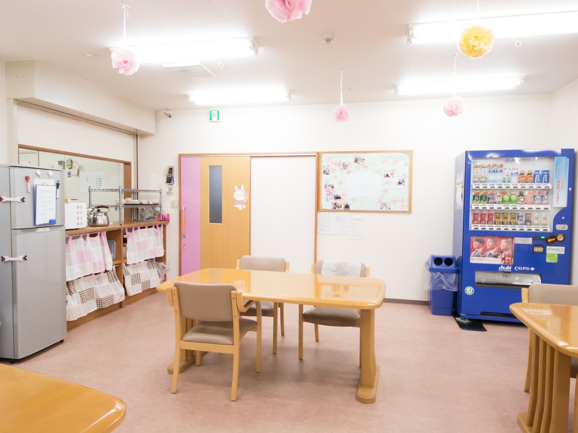 入居者様が集う共用スペースに、青色の自動販売機を設置している。いつでも好きなドリンクを購入し、椅子に座ってくつろげる。