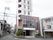 施設は縦に長い建物で、2階部分はガラス張りとなっている。入口には、白い看板に黒い文字で施設名の書かれた看板が掛けられている。