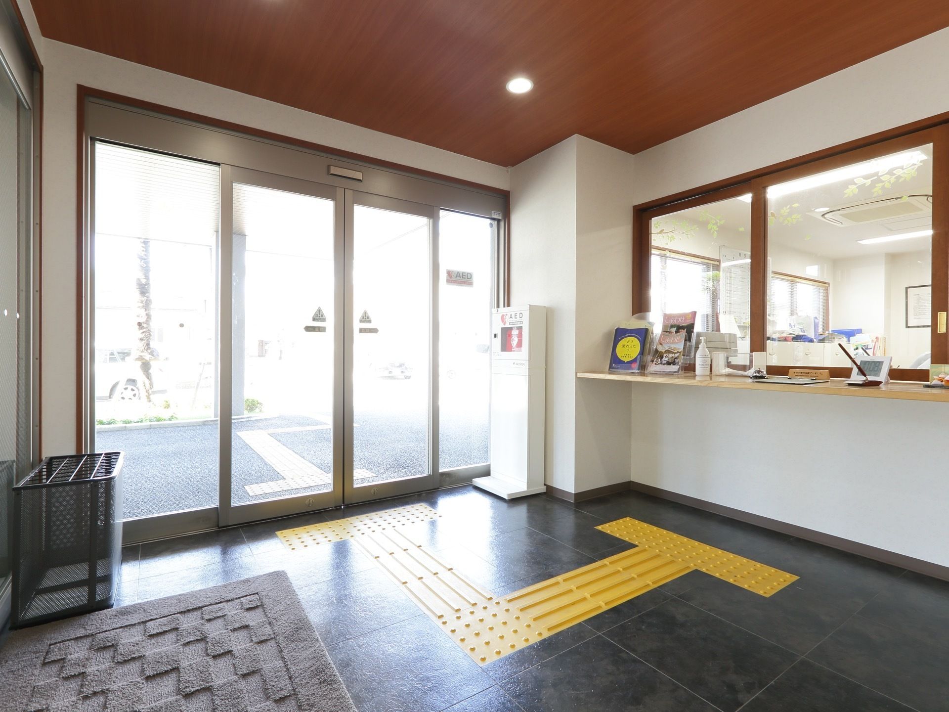 玄関から入って左側には大きな窓の受付がある。ここでは、来訪者から、訪問記録のために準備した一覧表に名前を書いてもらっている。
