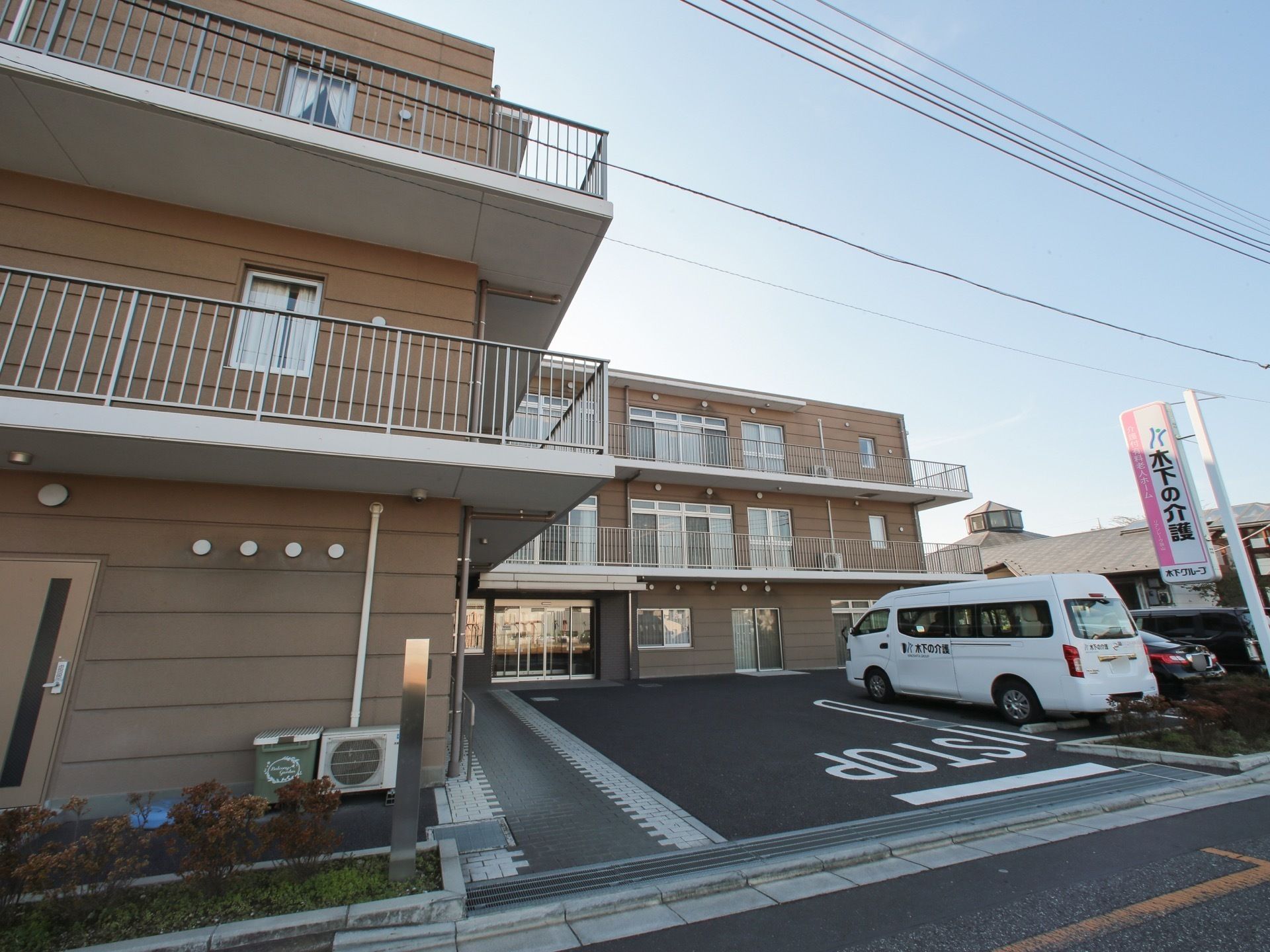 駐車場を設けベランダを完備している３階建て施設の外観