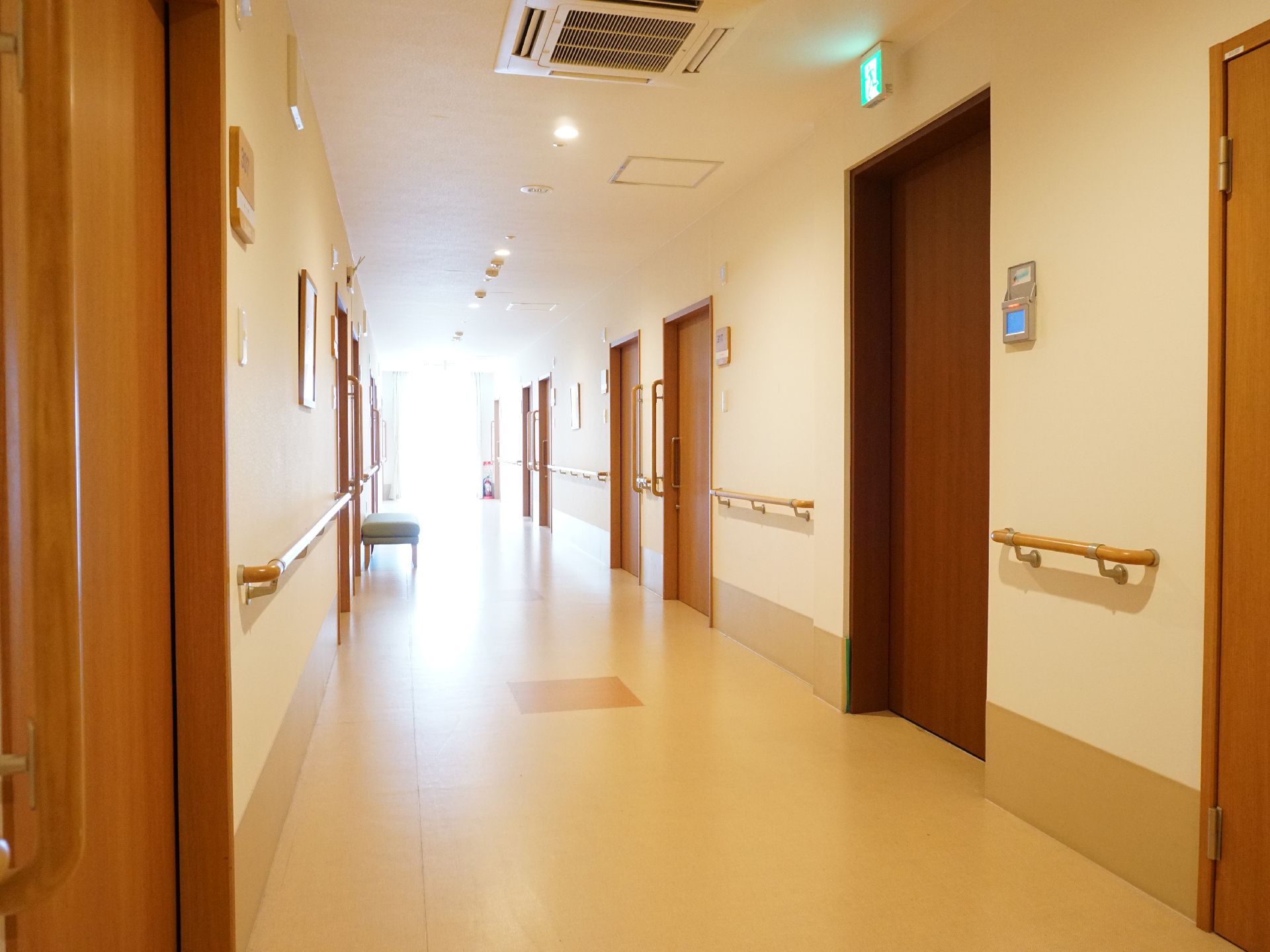 壁に手すりがあり、床の段差が取り除かれてバリアフリー化されている廊下