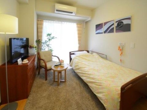介護用ベッドが置かれた側の壁に緊急呼び出しブザーが設置された居室