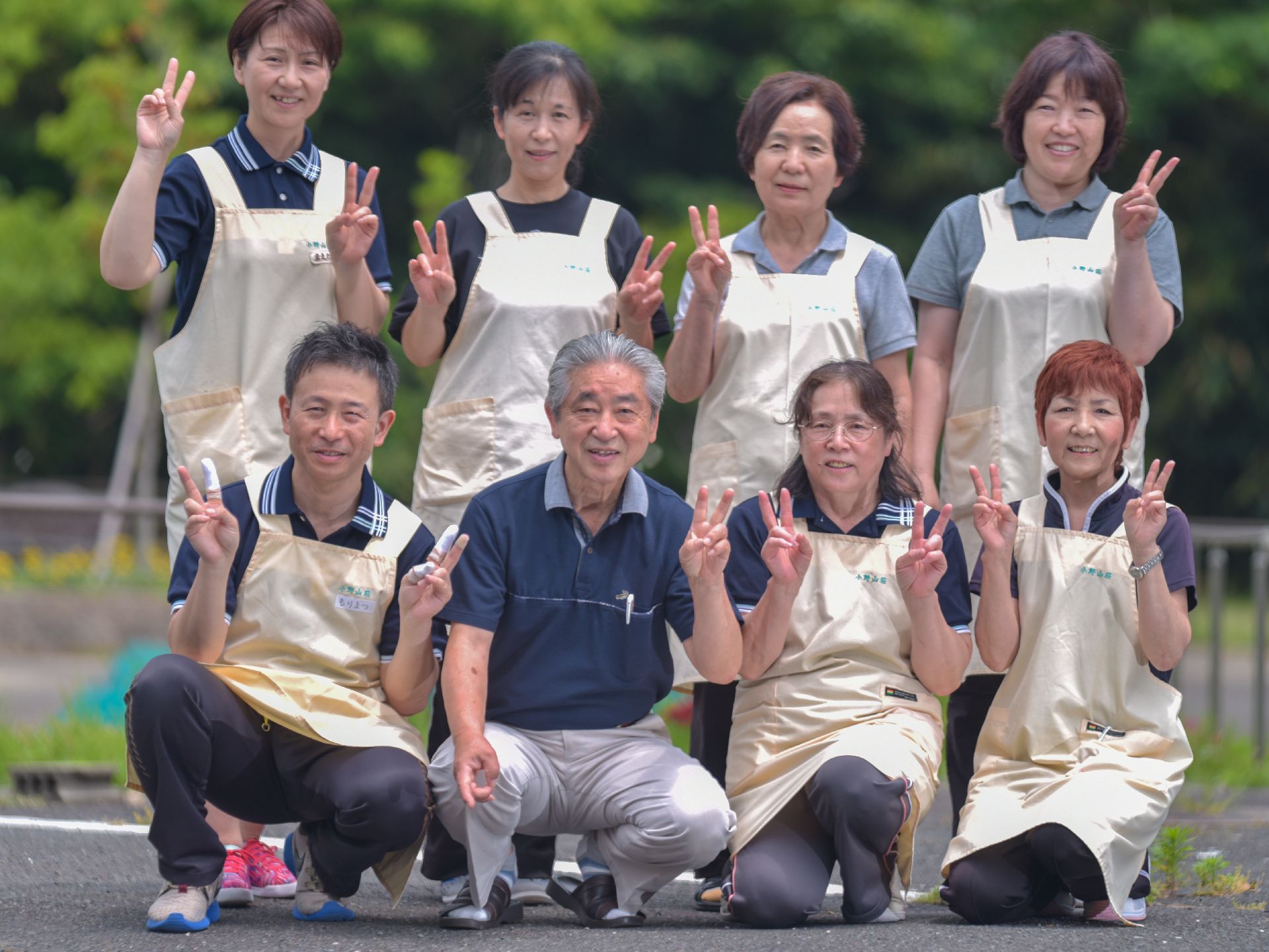 ２列になってこちらに向かって微笑むユニフォーム姿のスタッフ