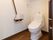 入口に引き戸が付いたゆったりとしたスペースに温水洗浄便座が付いた洋式トイレが設置されている。壁には手すりが付いている。