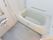 清潔感にあふれる浴室で、洗い場、浴槽は広い。温水シャワーを完備し、壁には縦・横に安全確保の為の手すりが設置されている。