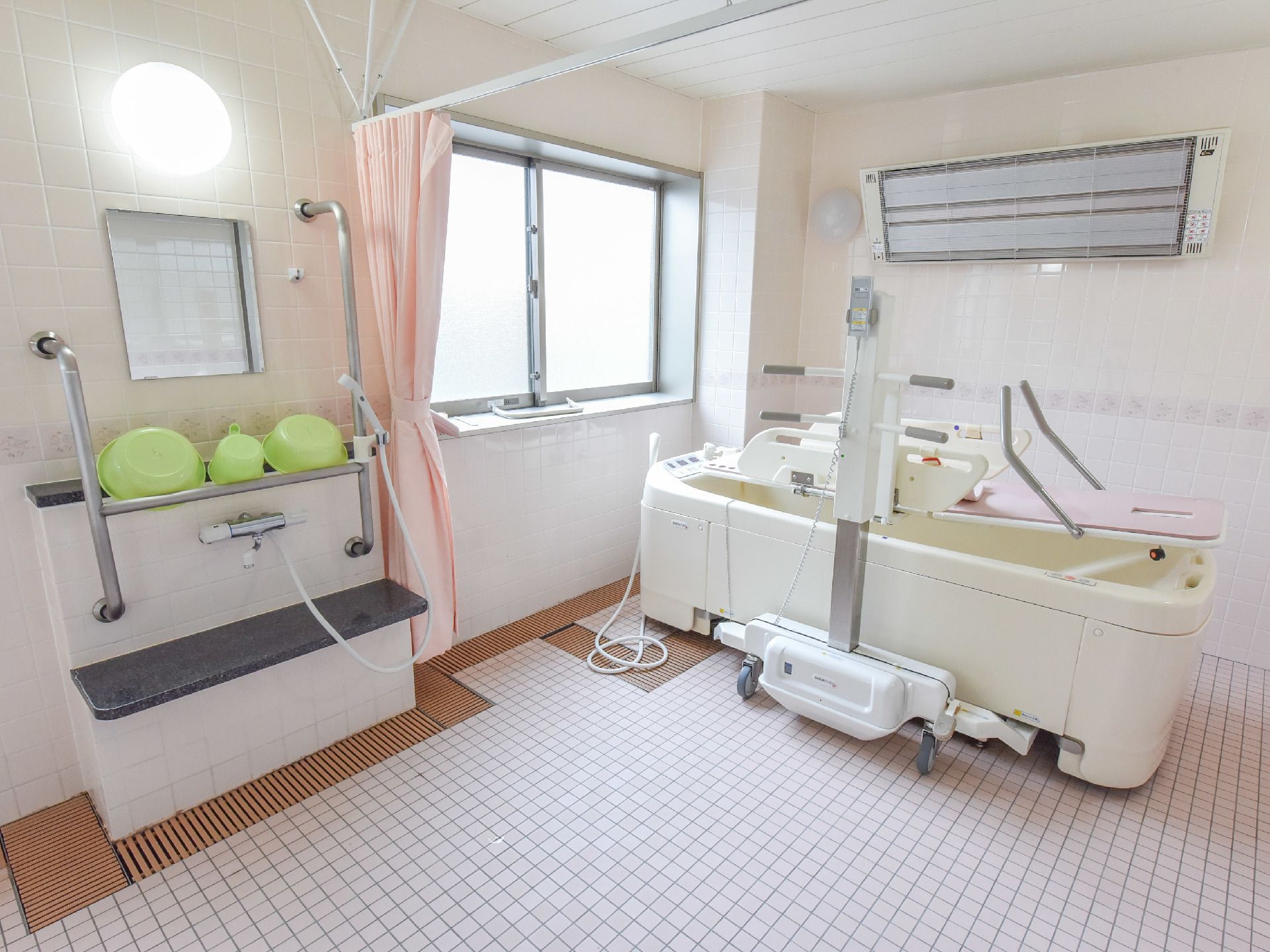 浴室の床や壁はタイル張りになっていて、大変清潔。壁には大きな窓がありとても明るい。浴室には機械浴が設置されている。