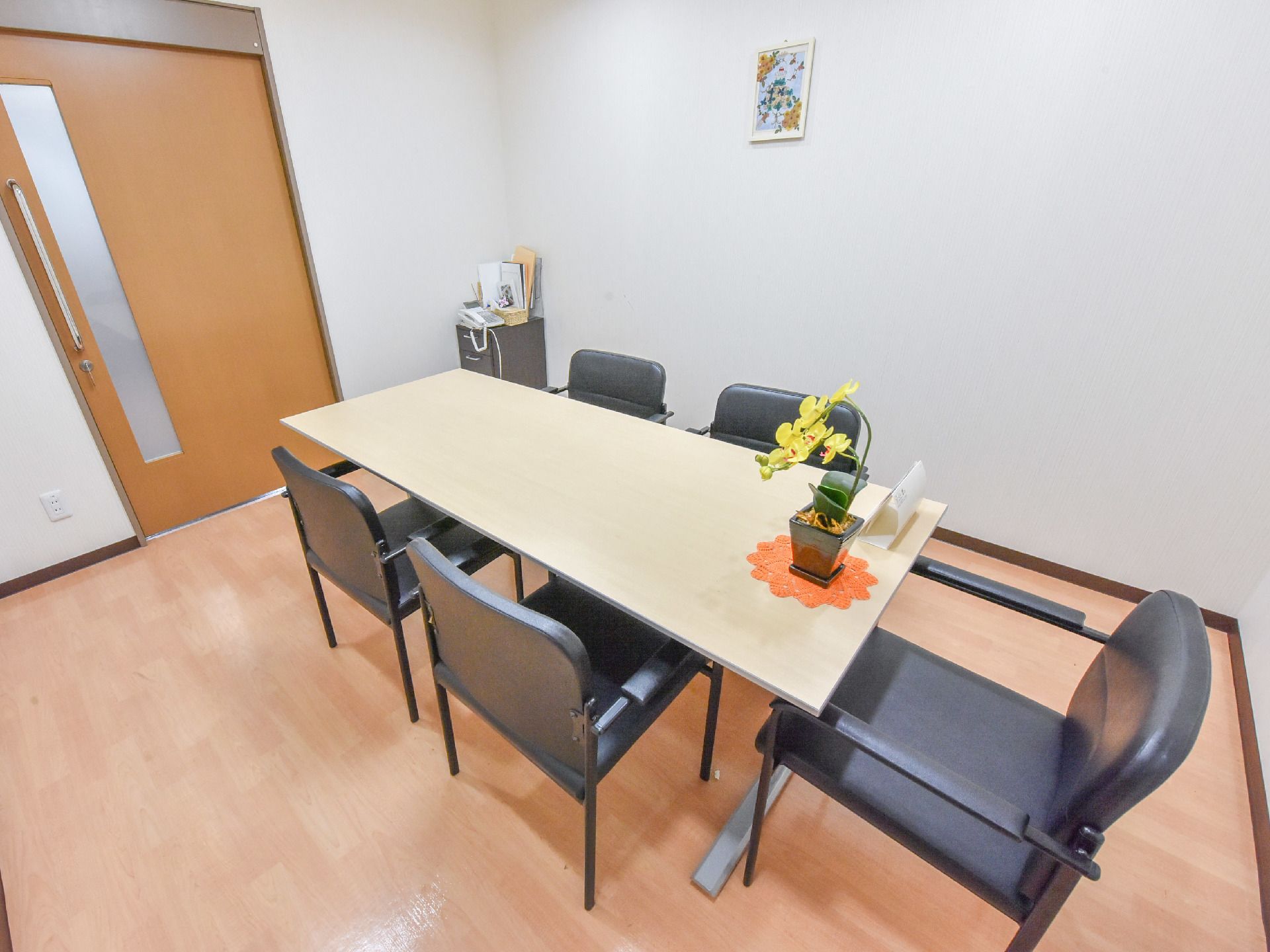 室内にはテーブルが置かれている。椅子が脚用意されている。話し合いのできるような空間になっている。テーブルには花が置かれている。