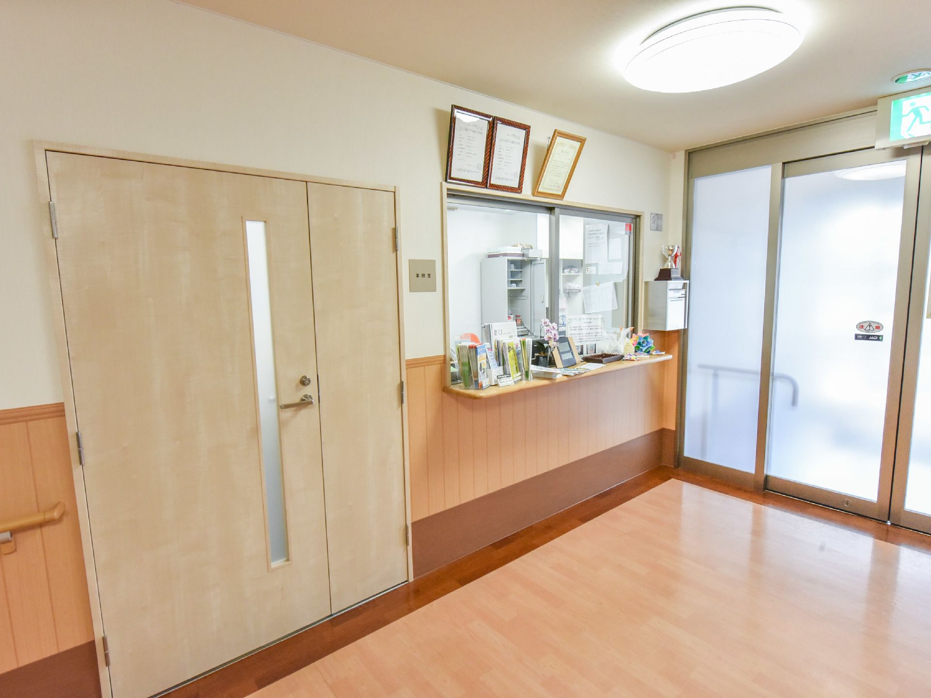 事務室近くの天井には照明があり、電気がついている。事務室をはさんで左側には中に入れるドア、右側には窓があって、中が見える状態になっている。