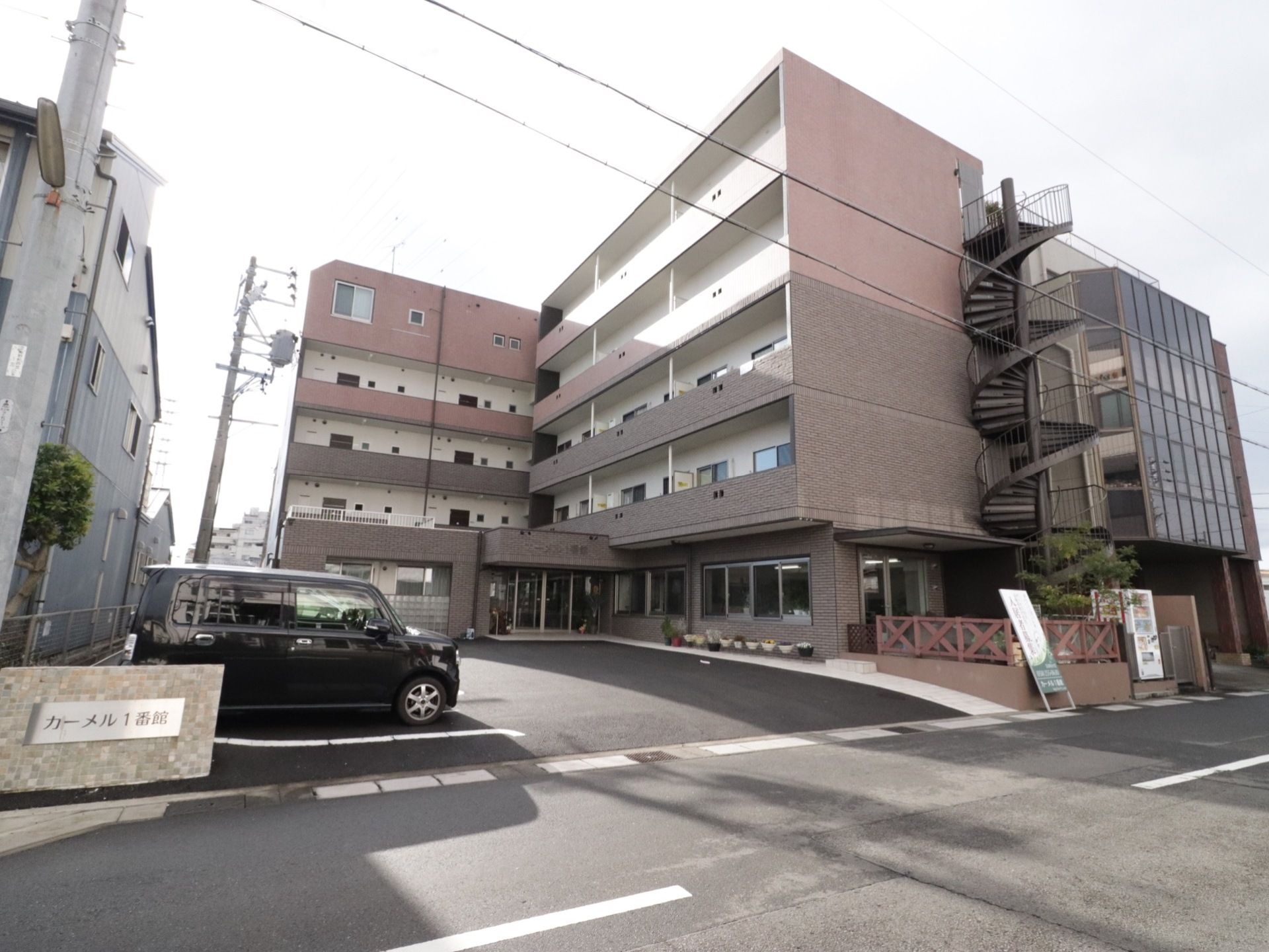 施設は道路に面していますが、玄関は奥まったところにある。車寄せを玄関そばまでできるので、歩行が困難な入居者様でも乗降が楽である。